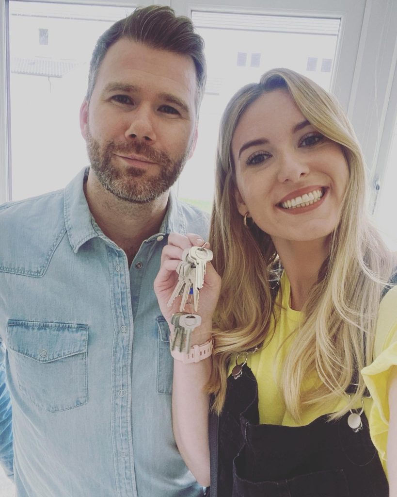 Couple holding keys to new home smiling