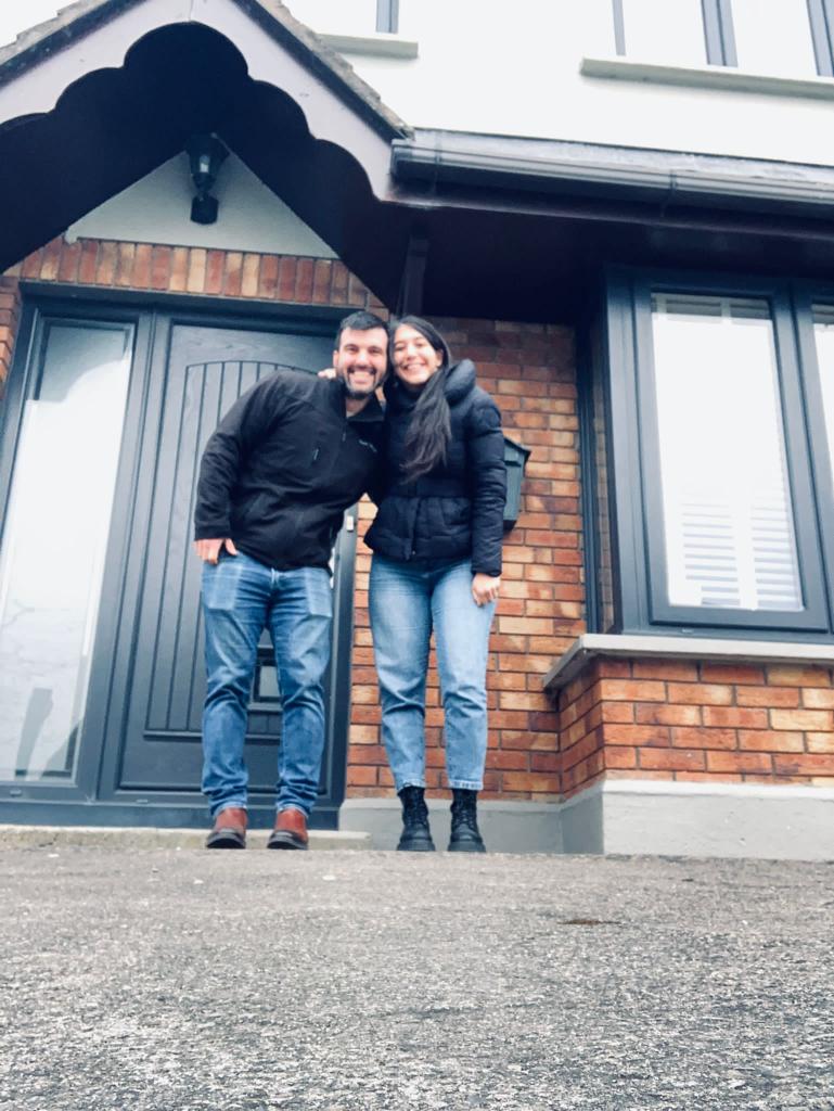 Couple smiling outside of their new home