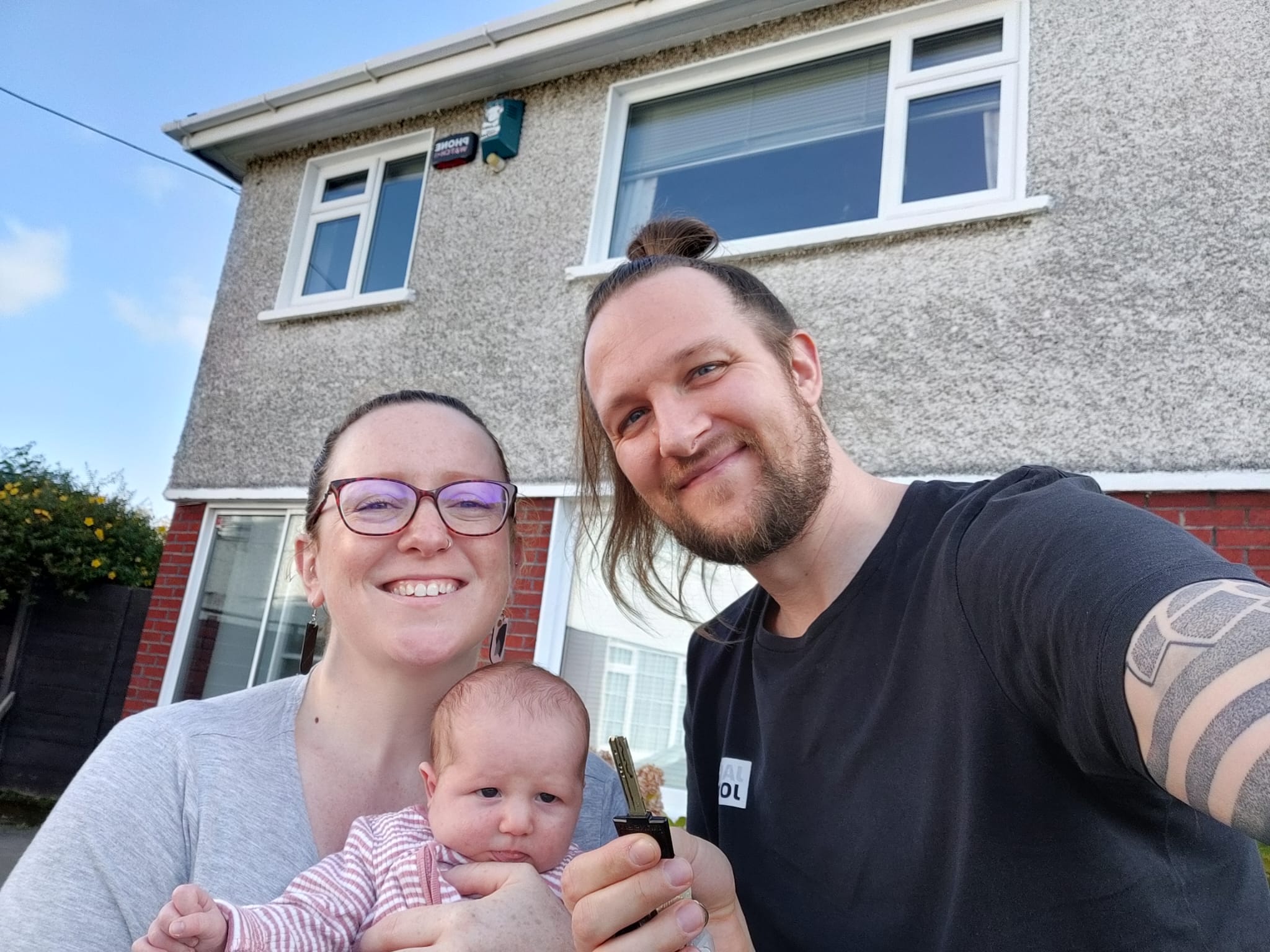 Family selfie in front of their house