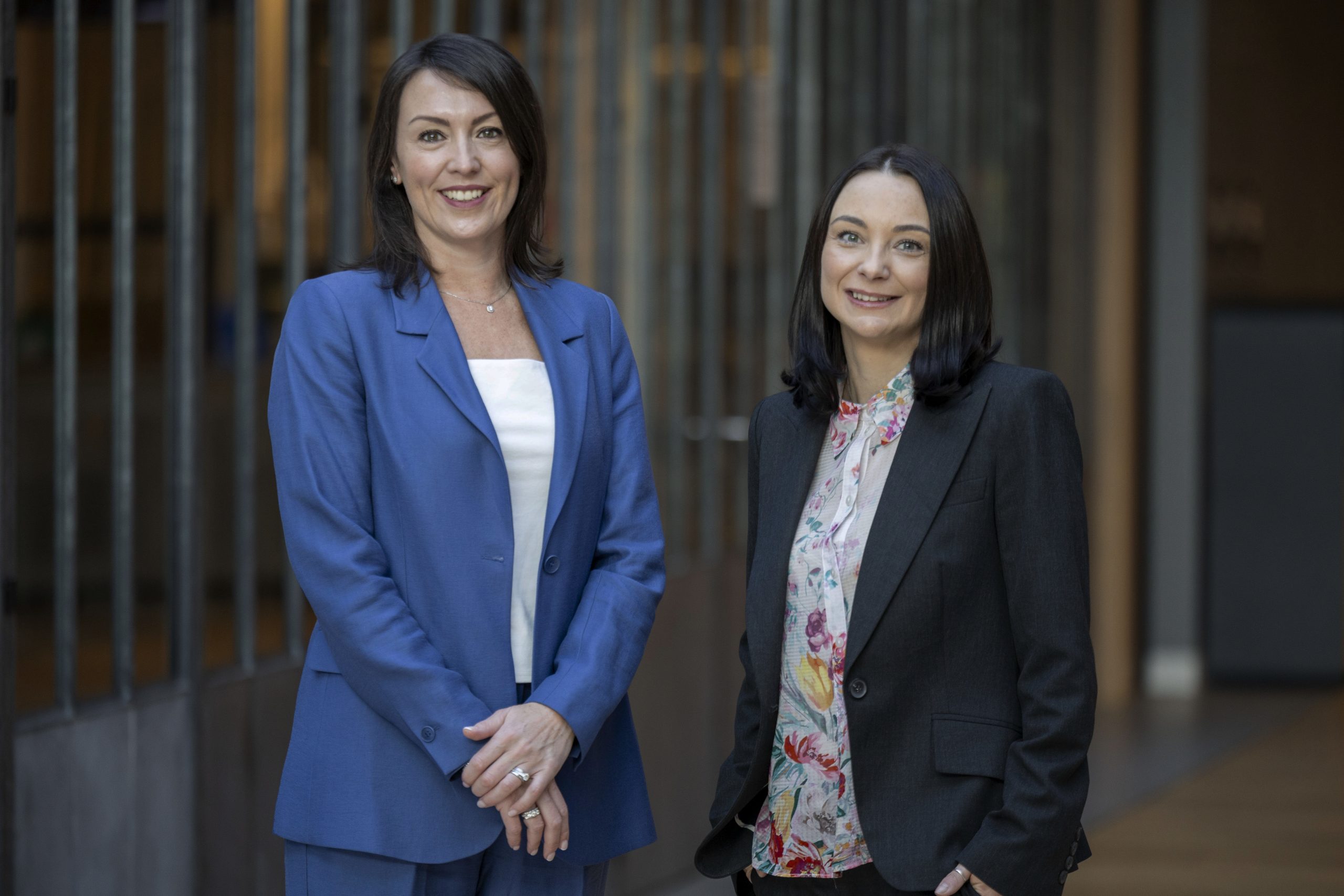 Two professional women smiling in an office setting