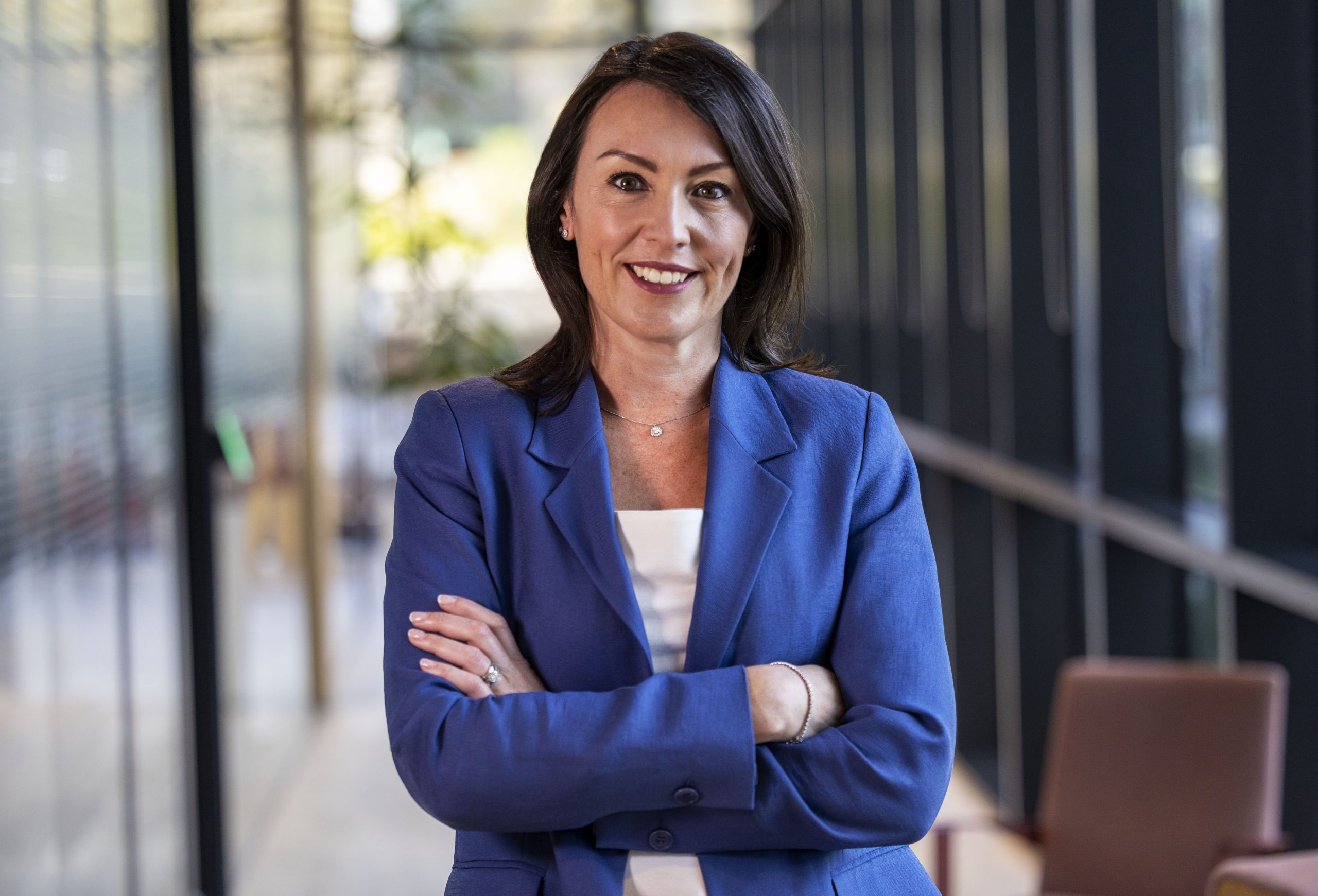 Confident businesswoman smiling in blue suit standing